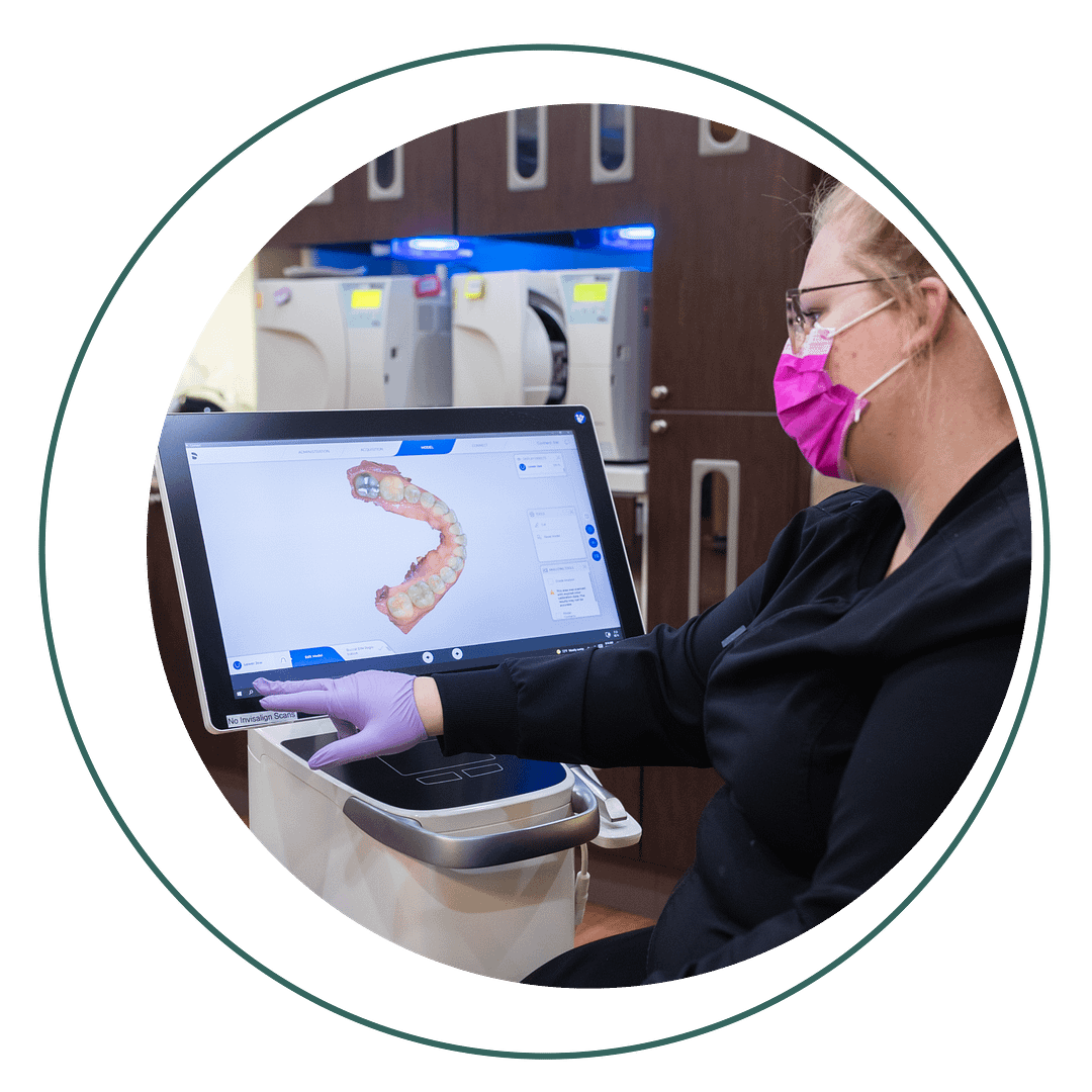 assistant looking at dental scan on iTero machine