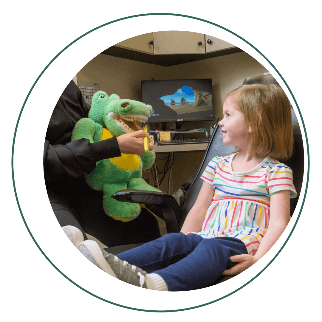 preventive-kids assistant showing pediatric patient how to brush teeth