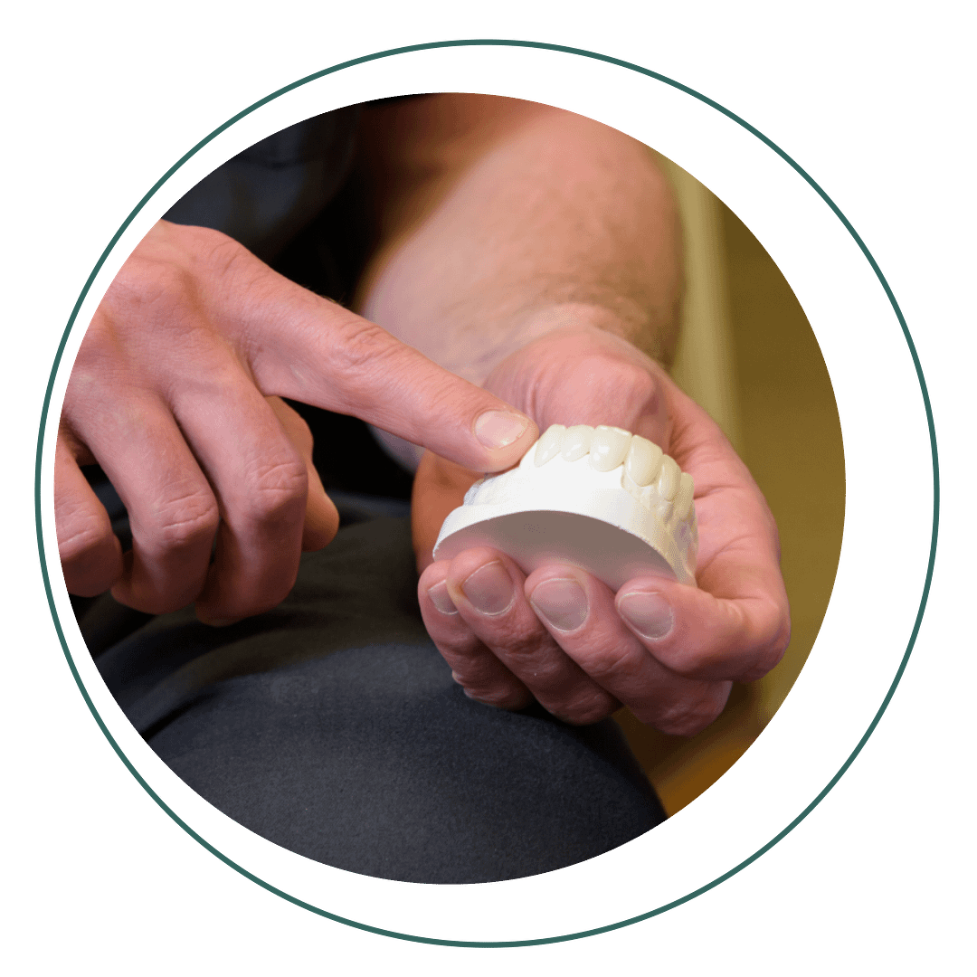contouring hand pointing to gumline on dental mold