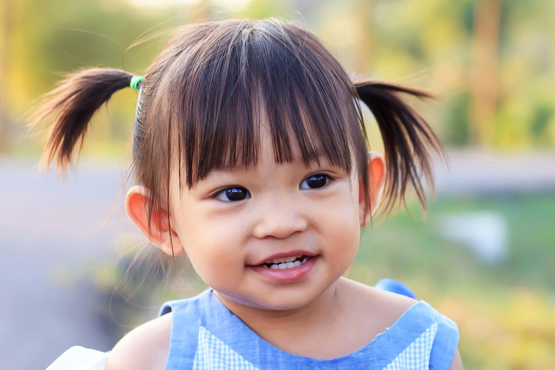 young Asian girl smiling and playing at the park