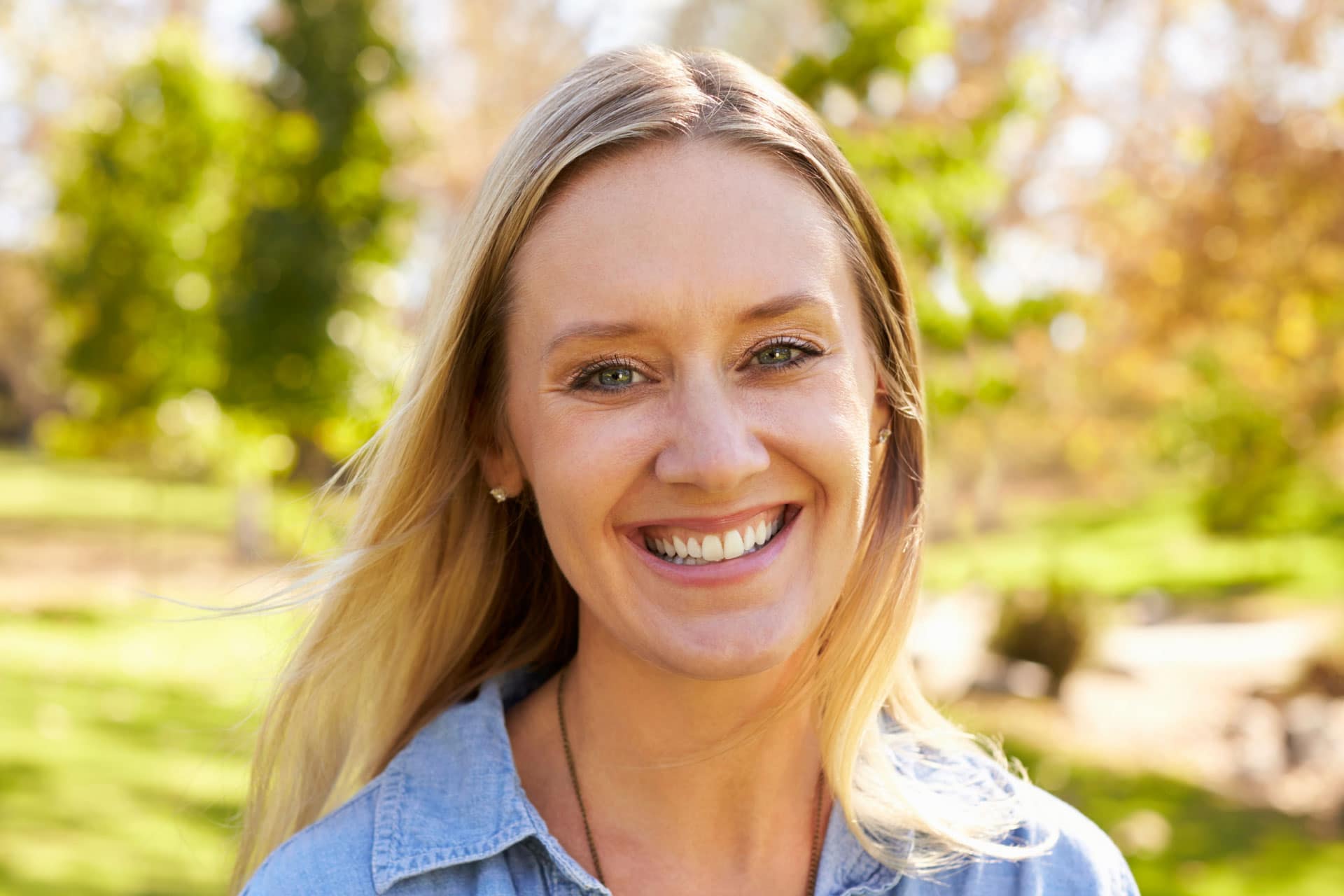 woman smiling at camera in a park