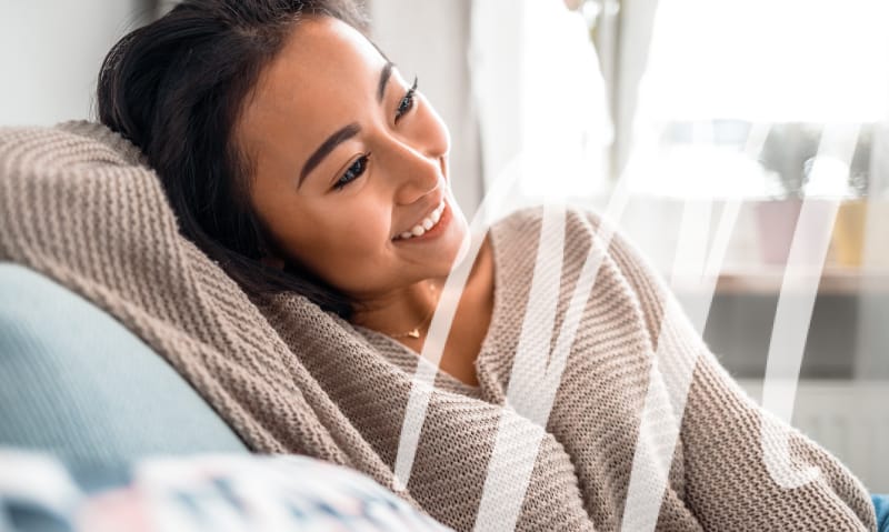 woman laying on couch smiling