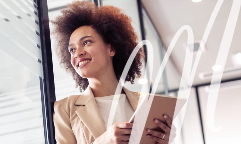 woman in suit on a tablet looks out her window