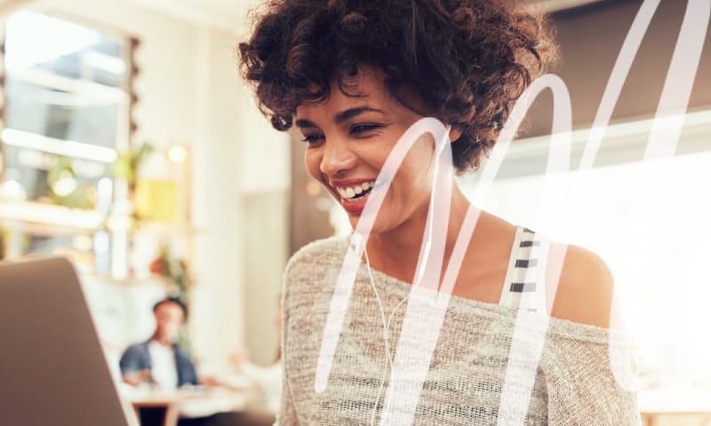 woman smiles and reads off of her laptop