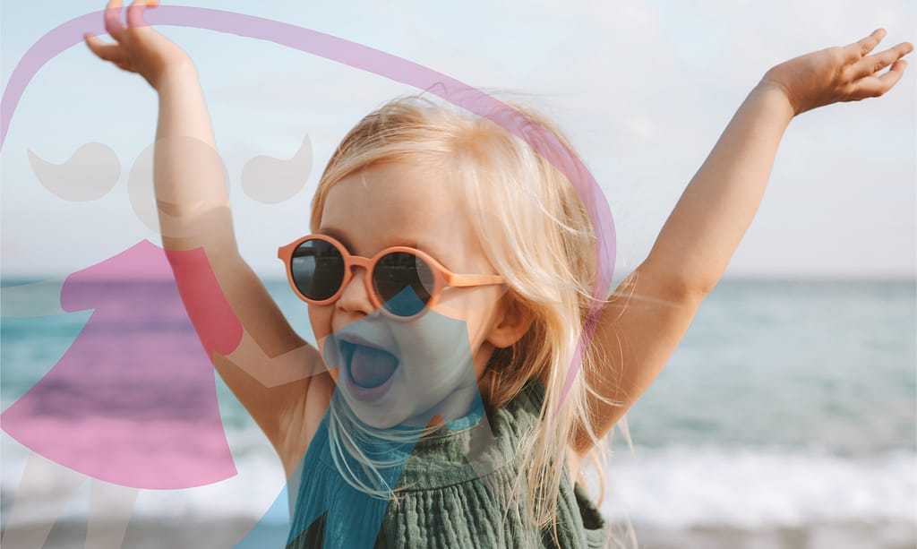 little girl having fun at the beach wearing sunglasses
