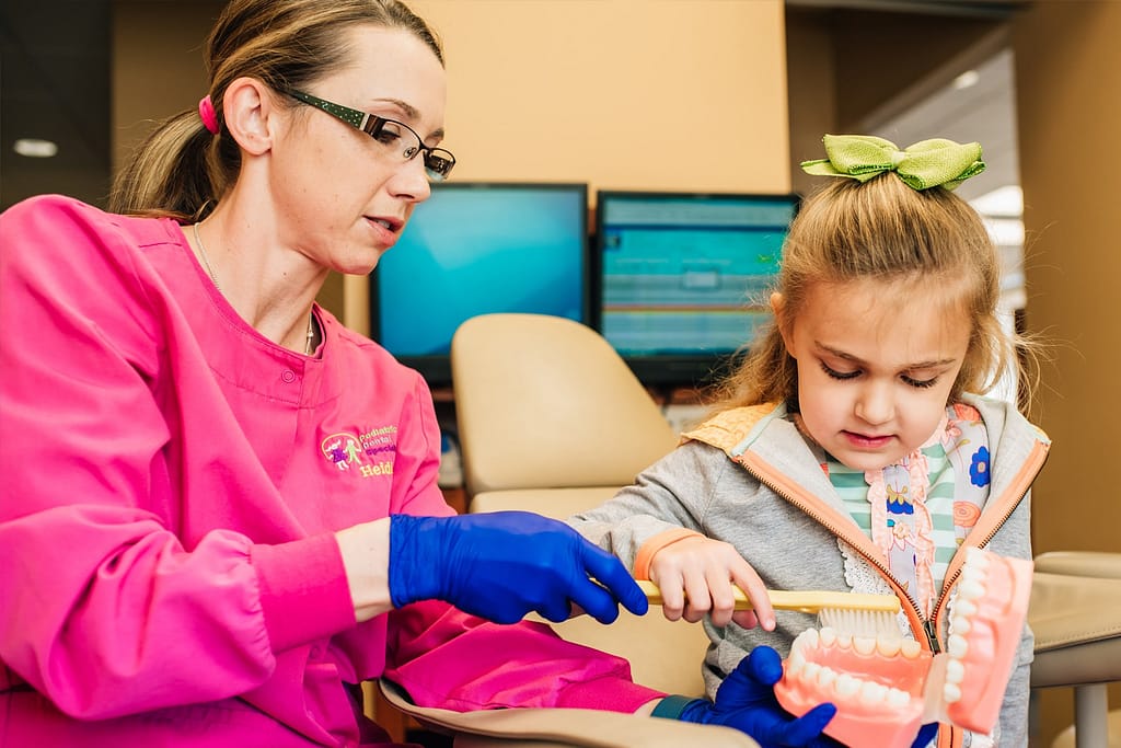 team member talking with young patient in chair
