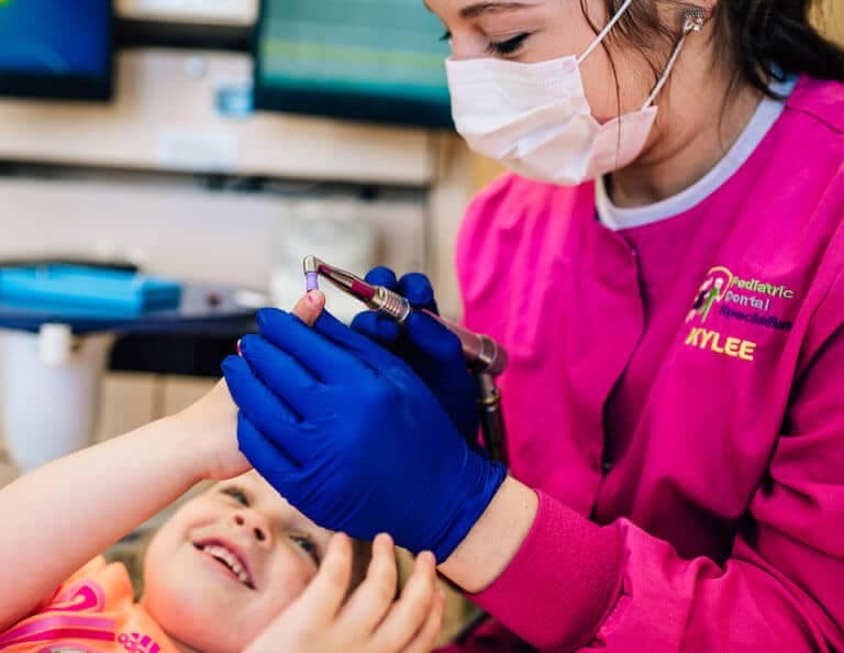 team member talking with young patient in chair