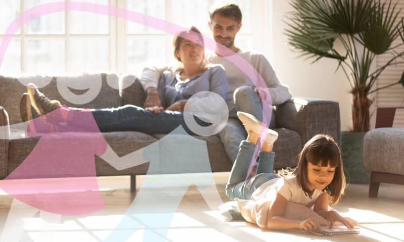 couple on couch while girl plays on floor
