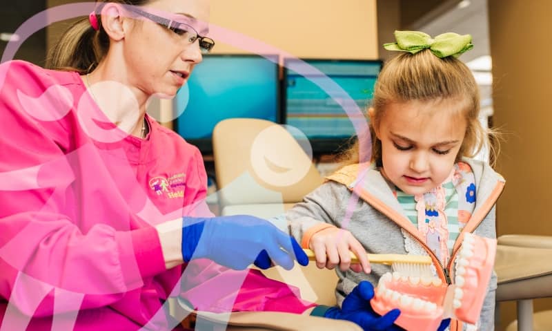 team member talking with young patient in chair