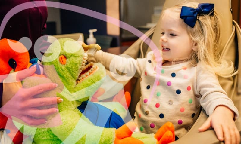 kids-brush-teeth-PDS team member talking with young patient in chair with stuffed animal
