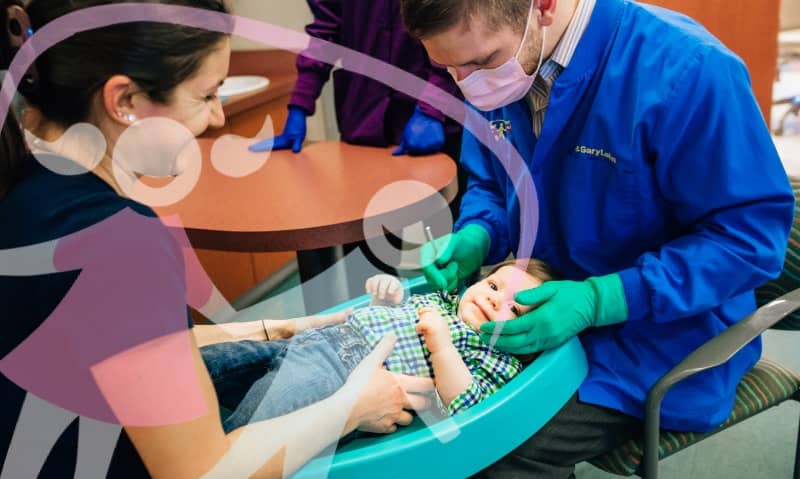 team member working with young patient in chair