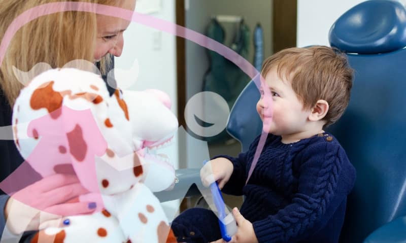 team member talking with young patient in chair