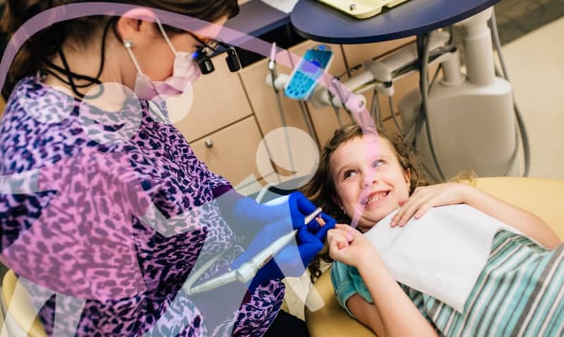 team member talking with young patient in chair