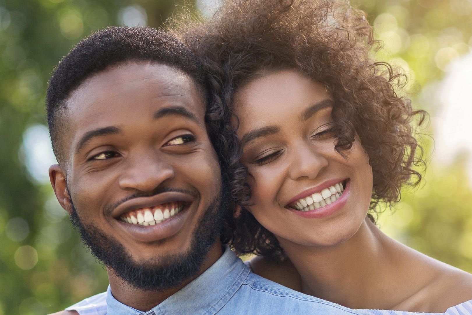 young african american couple hugging and smiling