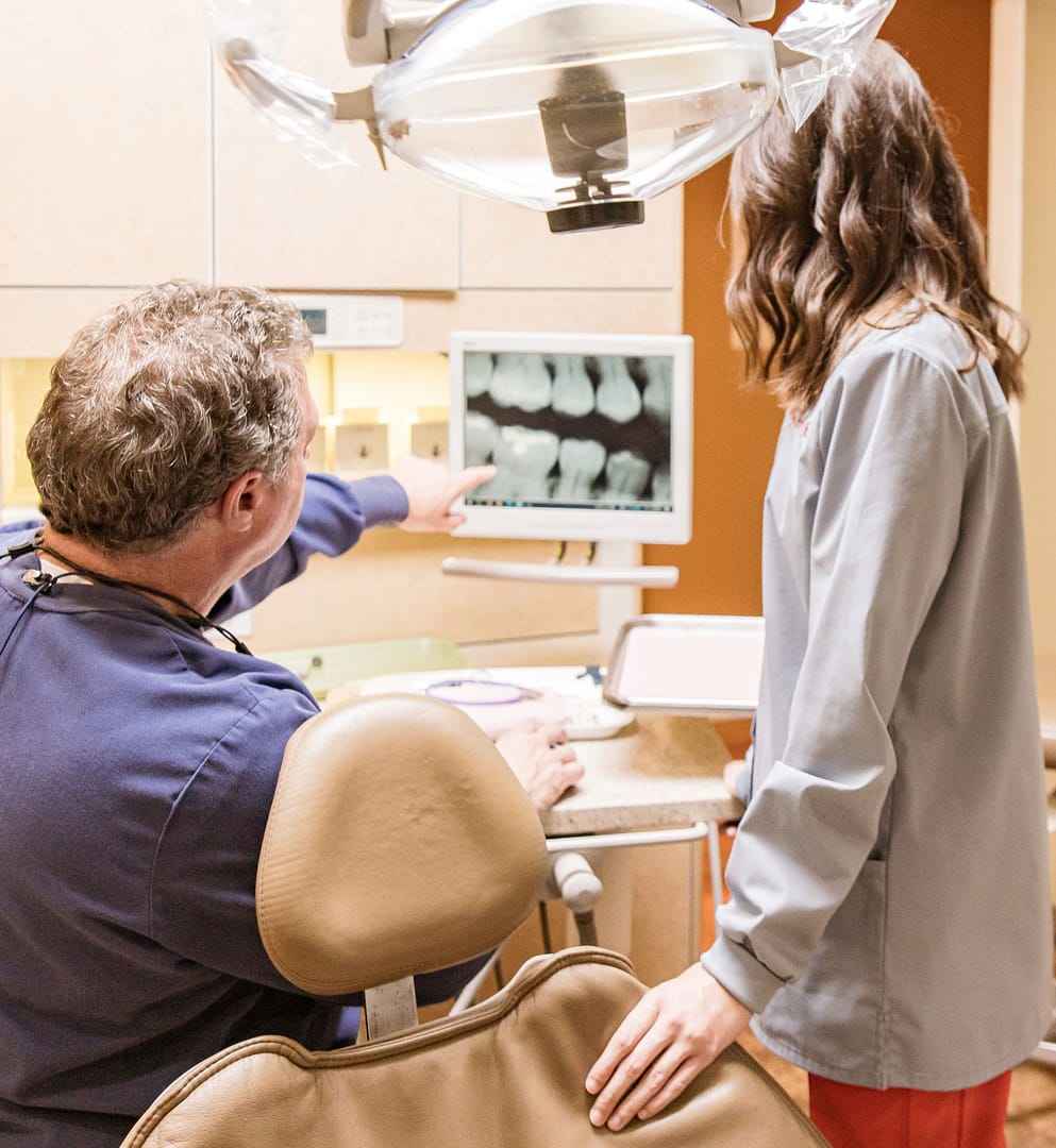 Dr. Sexton showing dental xray to team member on computer screen