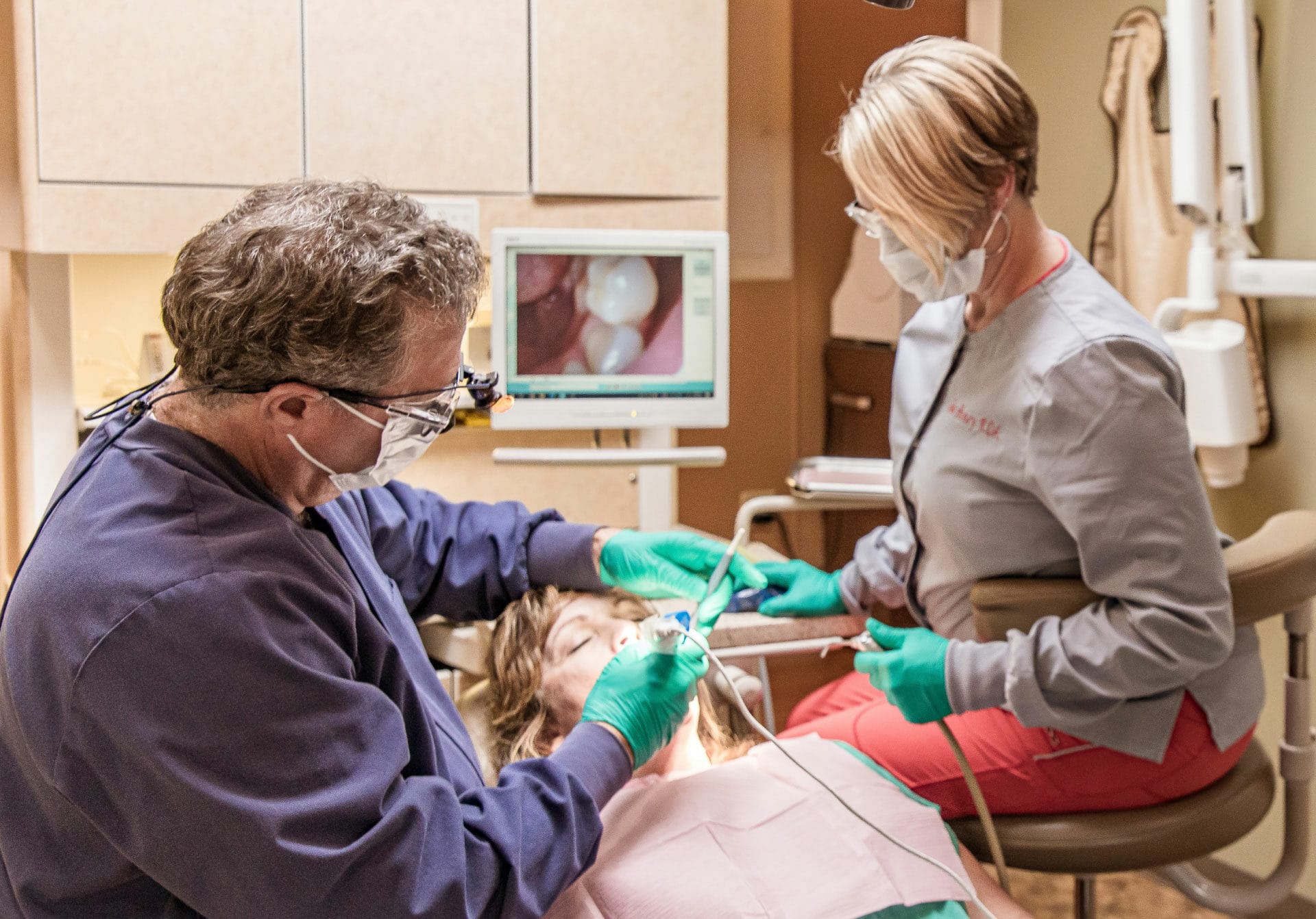 Dr. Sexton and assistant performing dental procedure on adult patient