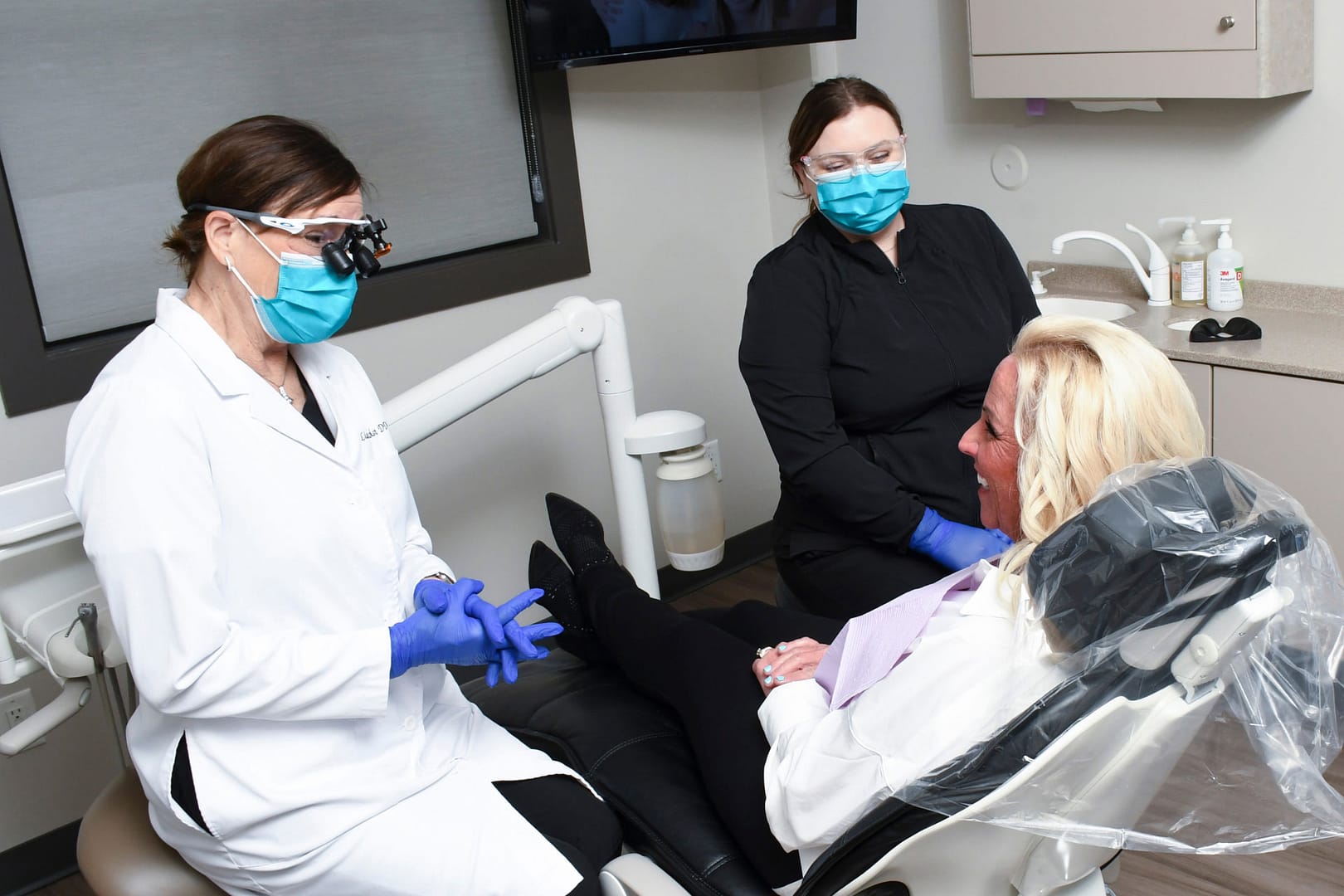 Dr. Holst and assistant talking with patient in exam room