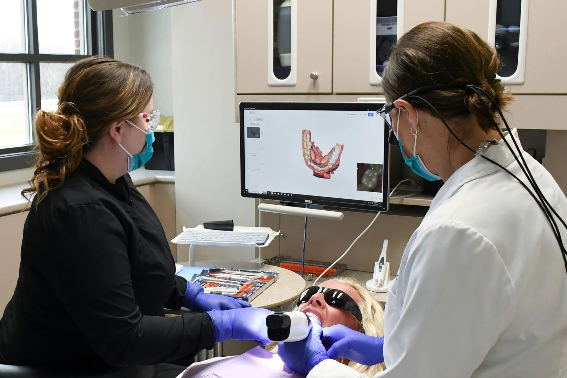 Dr. Holst and assistant using intraoral camera on patient while looking at dental image on computer screen