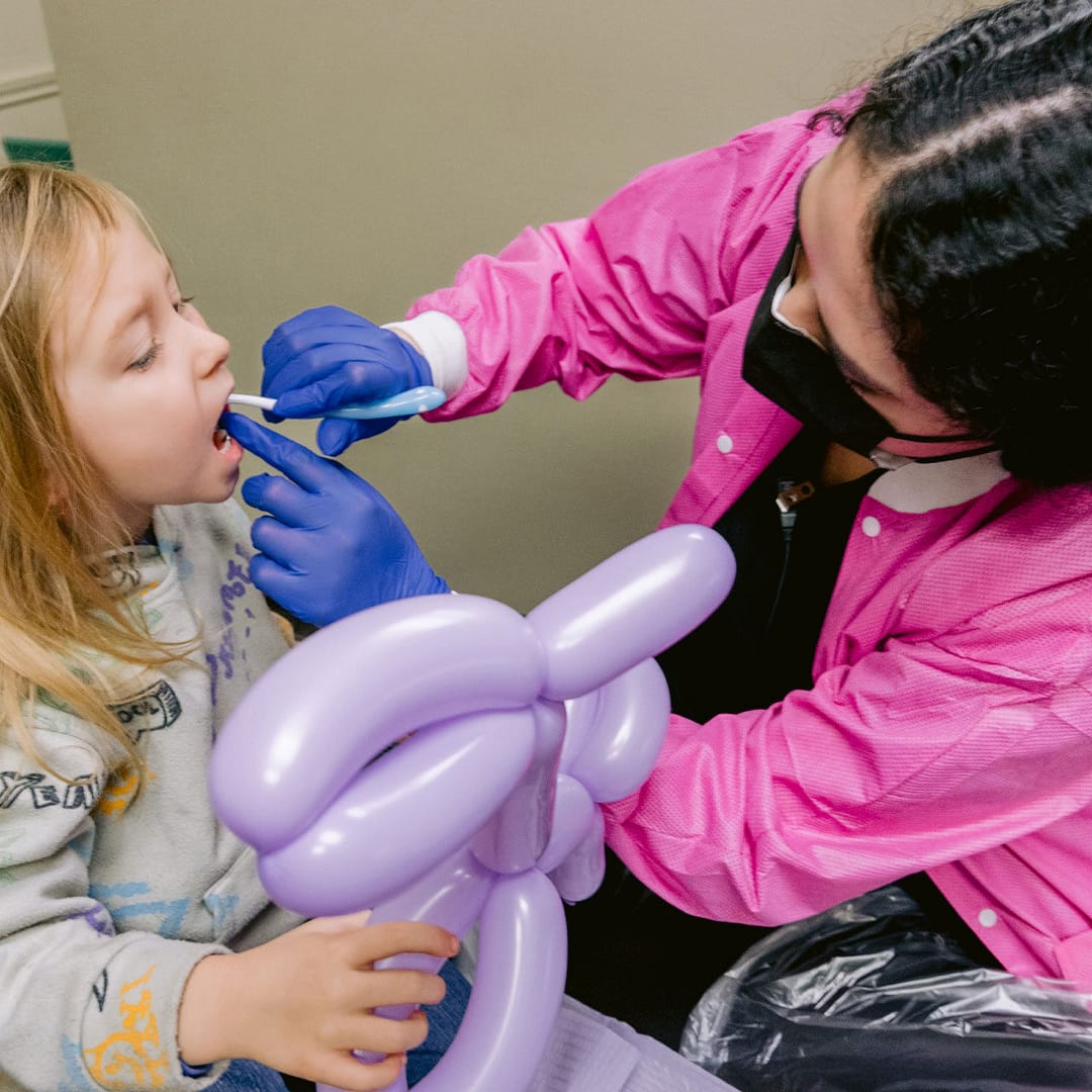 team member with pediatric patient in exam room