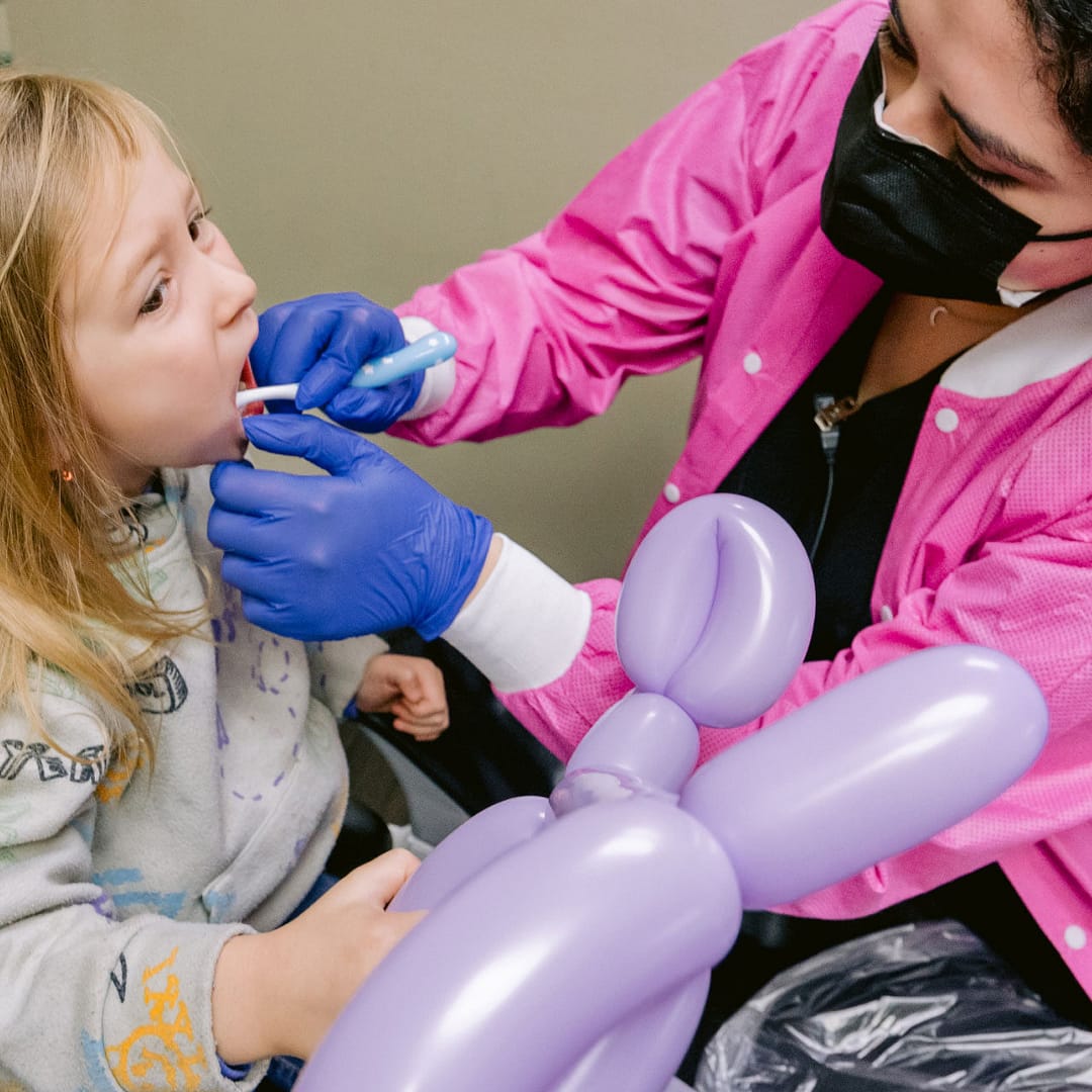 team member with pediatric patient in exam room