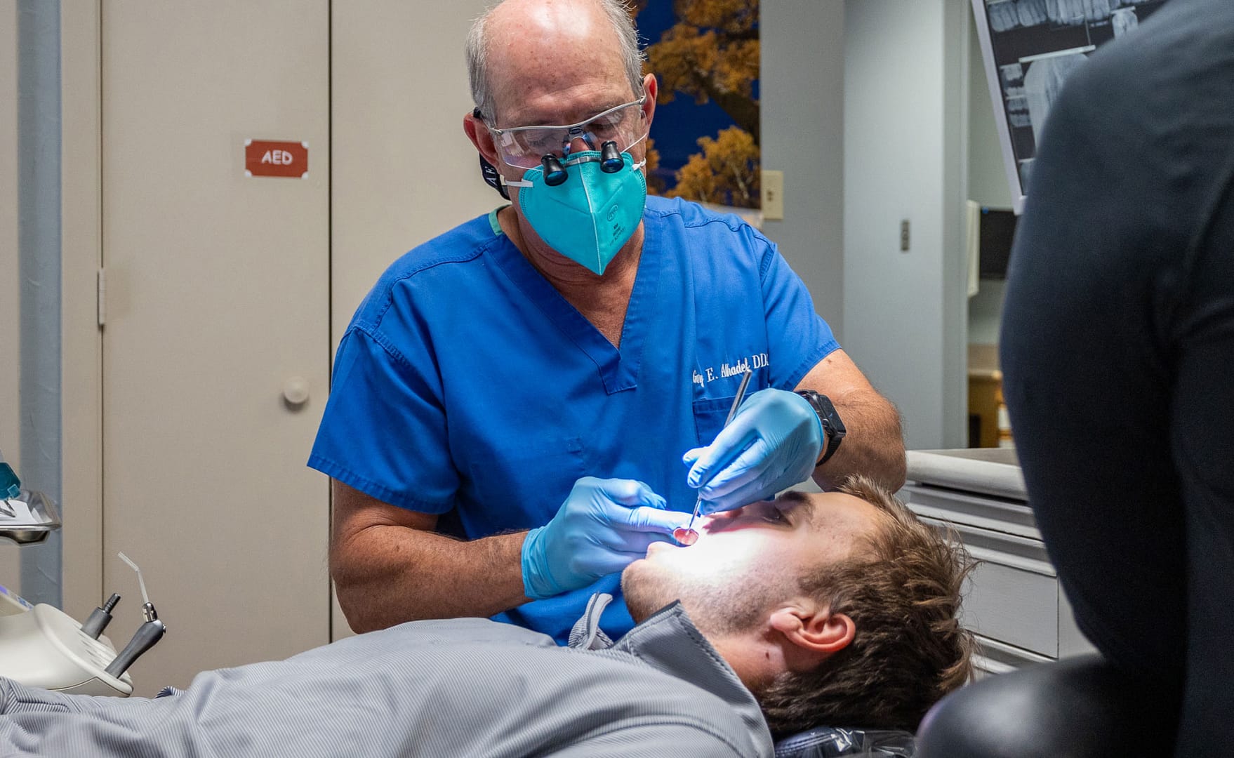 Dr. Alhadef performing dental exam on patient in dental chair