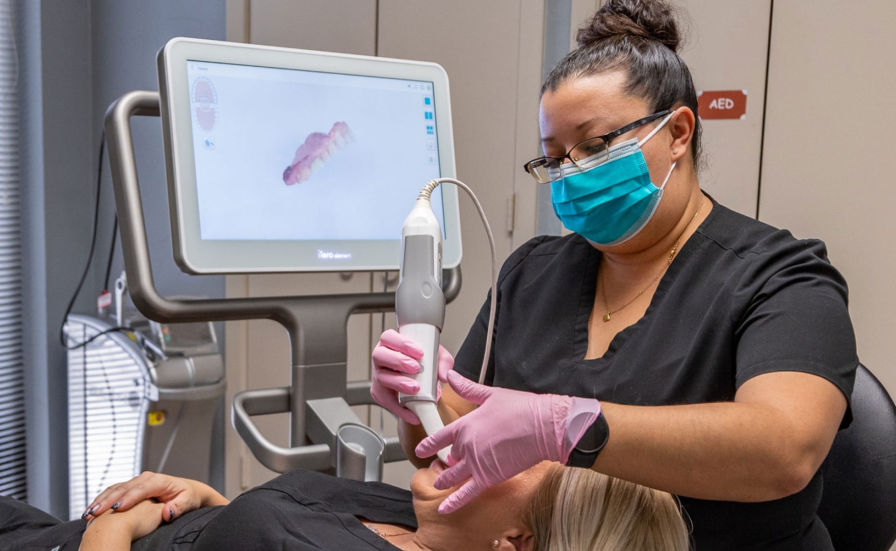 dental team member using iTero machine to take scan of patient's teeth