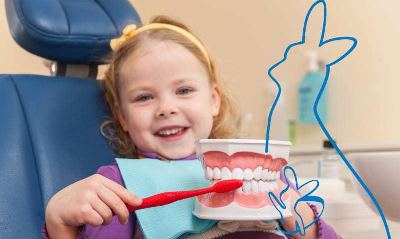 Pediatric patient demonstrating how to brush teeth on a model