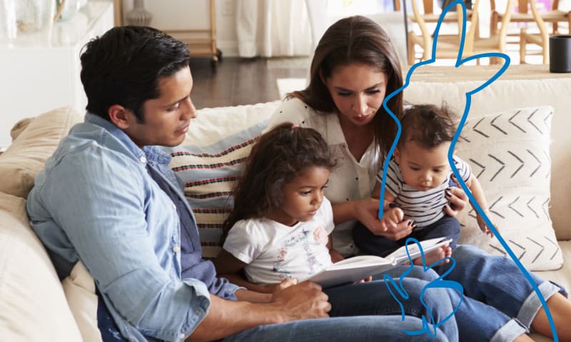 family of four reading a book