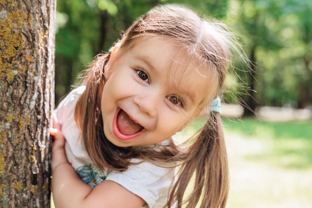 pediatric patients smiling by tree