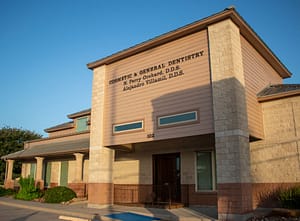 Large beige stucco office building housing Orchard Dental Associates