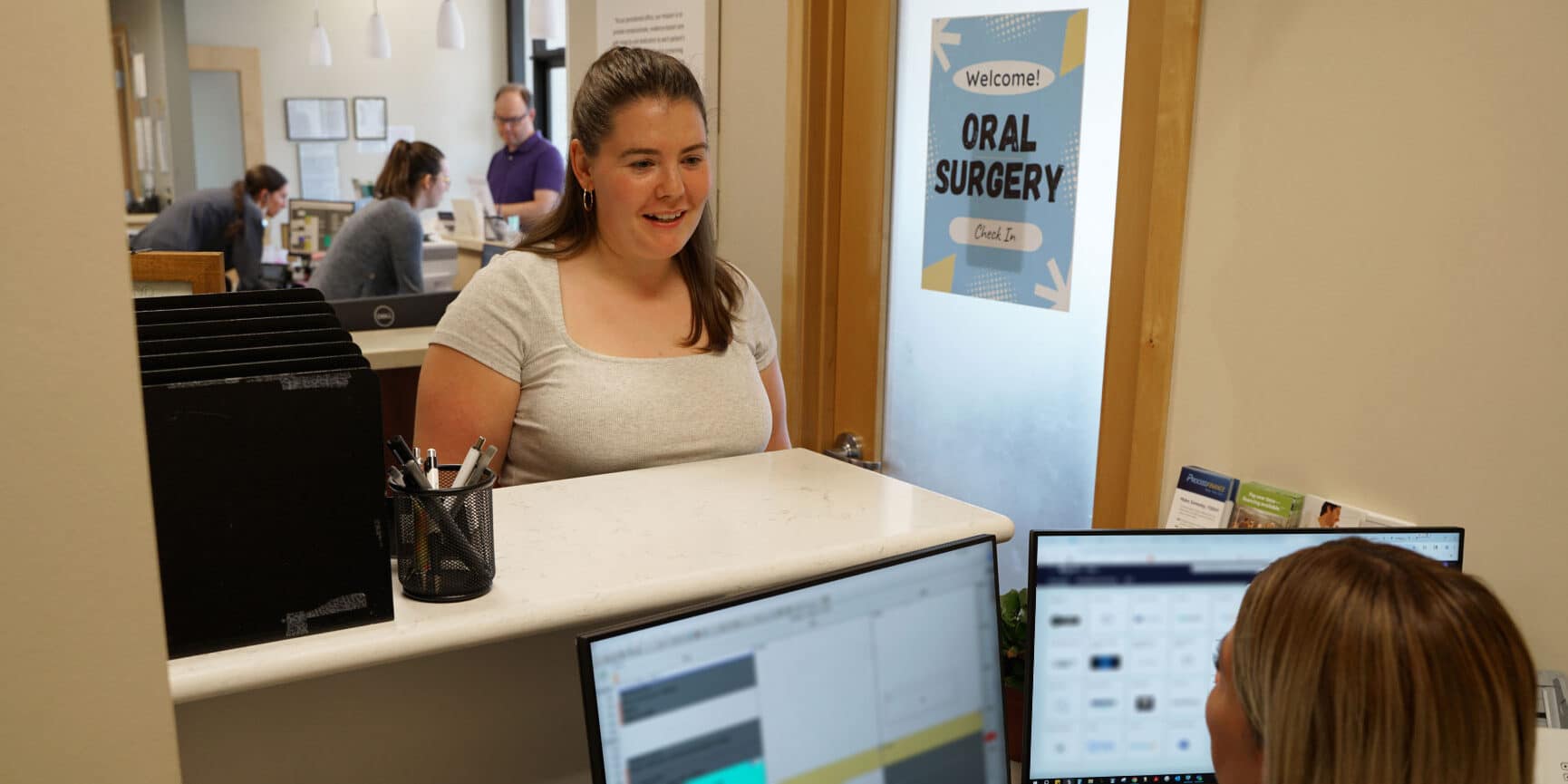 patient talking to team member at front desk