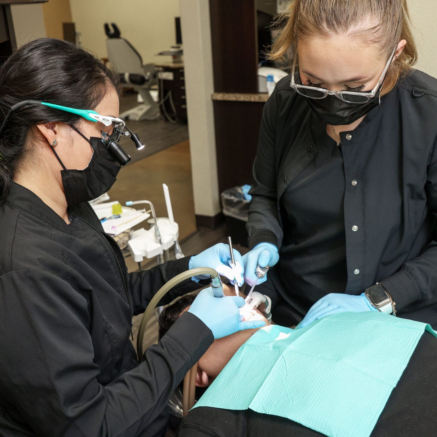 cosmetic-home-feature dentist and team member with patient in exam room