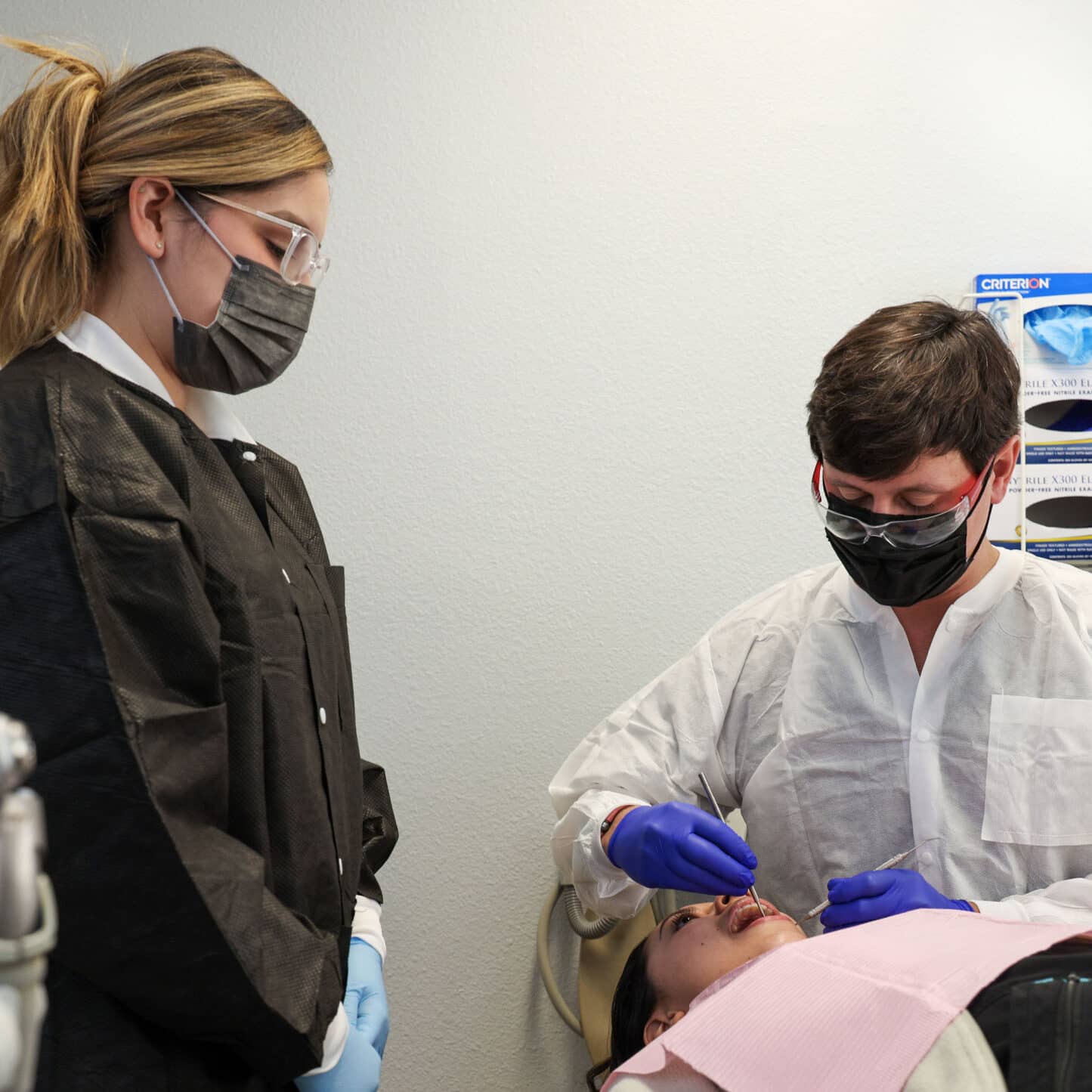 restore-home-feature dentist and team member with patient in exam room