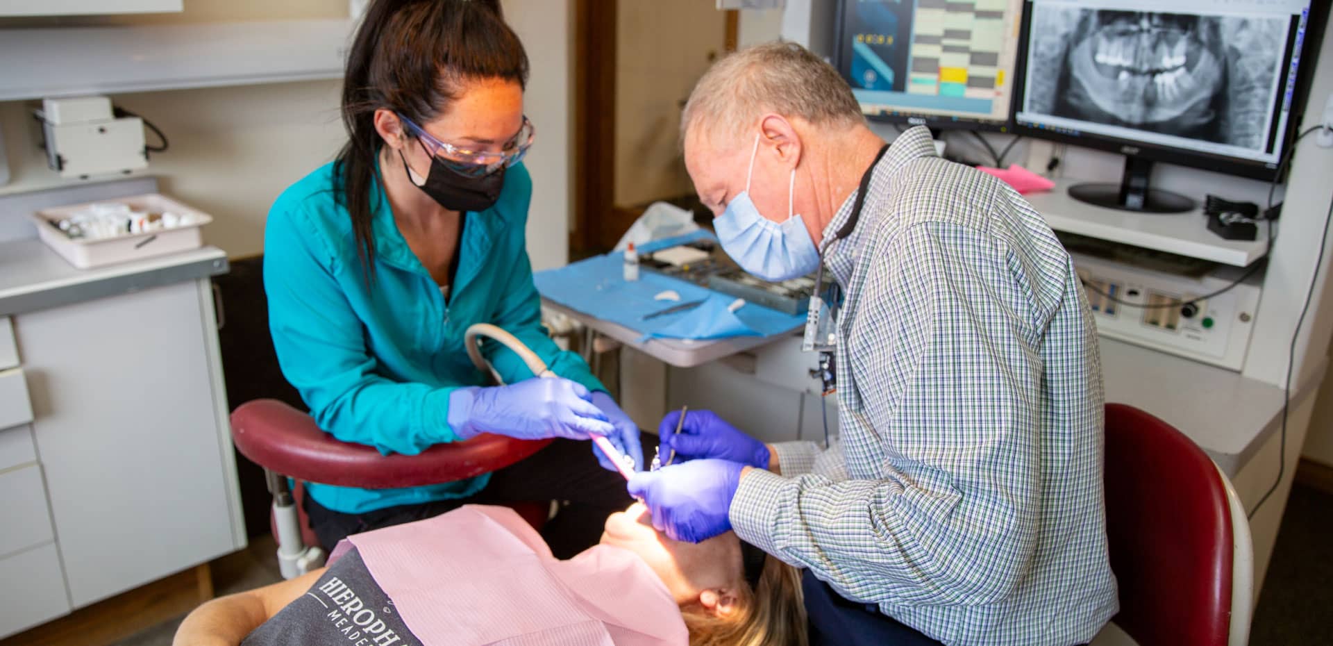 restorative-hero Dr. Spencer and team member performing dental procedure on patient