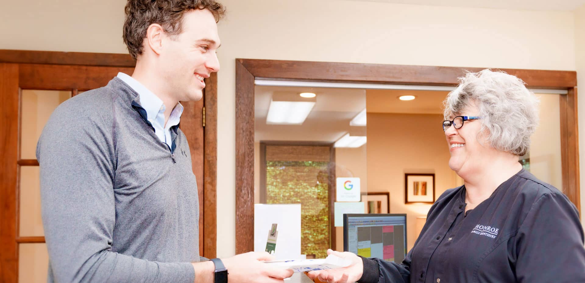 plan-your-visit-hero team member helping patient at front desk